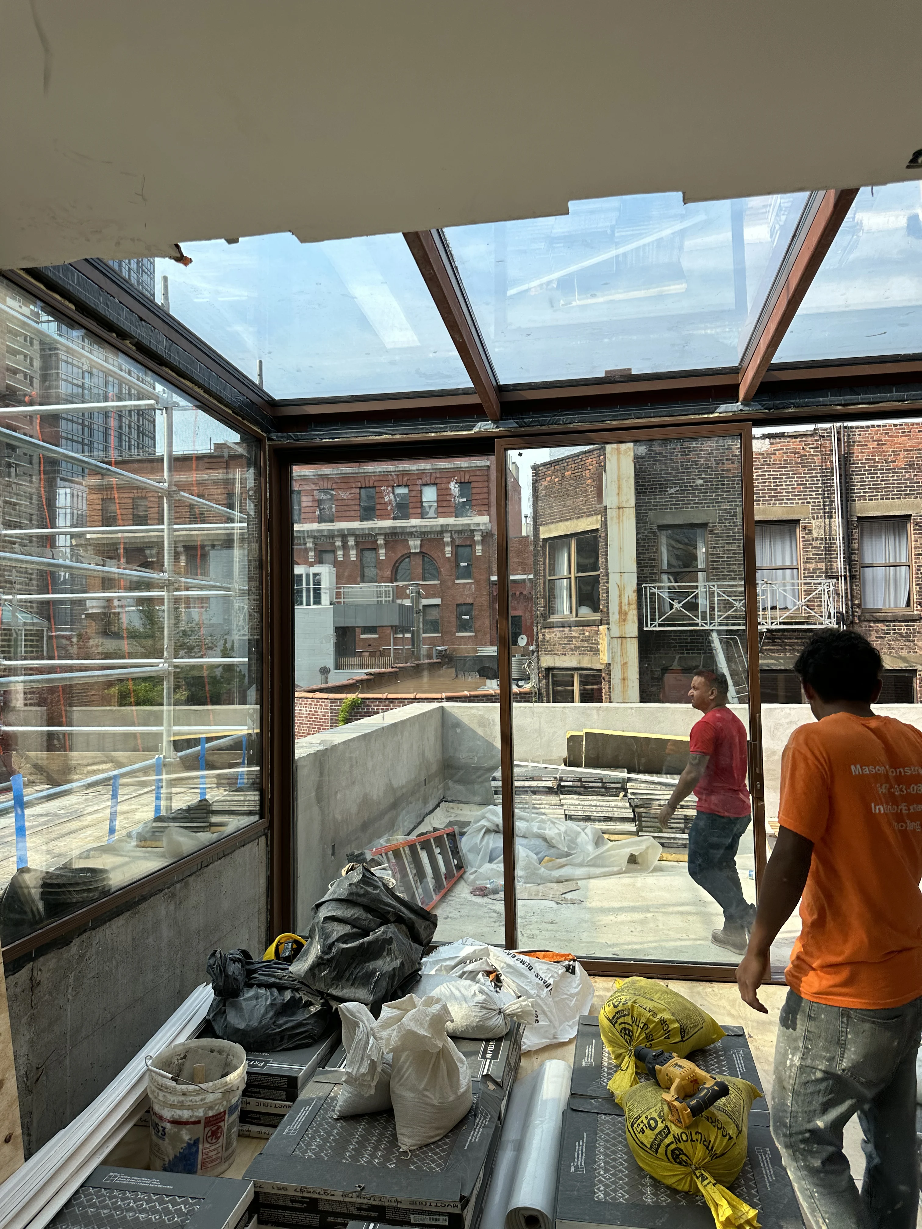 Interior renovation with glass roof and brick backdrop in progress by Mason Construction in Brooklyn